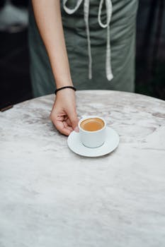 Crop barista serving cup of coffee