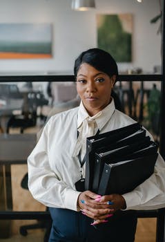 Confident female accountant carrying documents