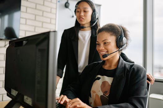 Two women with headsets working as call center agents