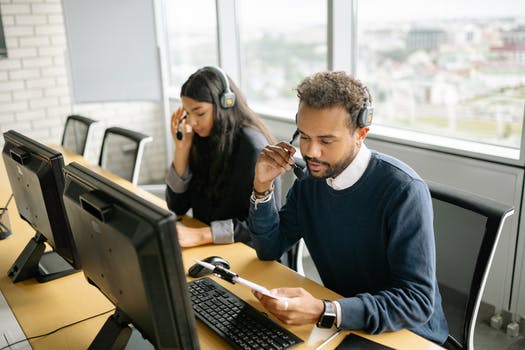 A man and woman working in the call center together