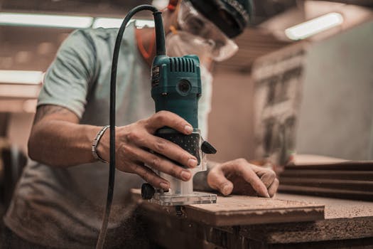 Person holding green and black power tool