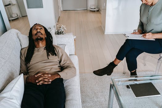 Black man lying on sofa in psychological office