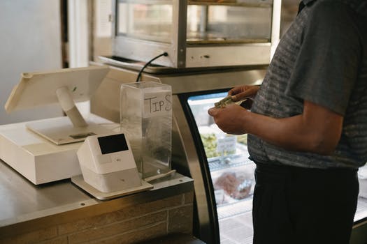 Crop man standing near cash machine