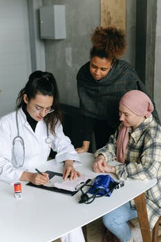 Woman in white coat sitting beside man in black and white plaid dress shirt