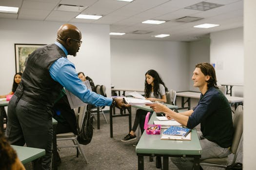 Teacher giving the test result to his student