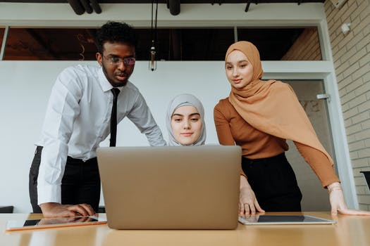 A low angle shot of people looking at laptop