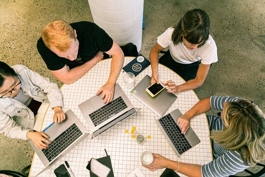 Four people using laptop computers and smartphone