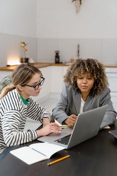 Two women brainstorming a business project at a meeting