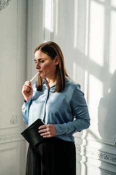 Woman in blue zip up jacket holding black leather wallet