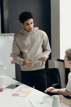 Man in gray sweater standing beside a man