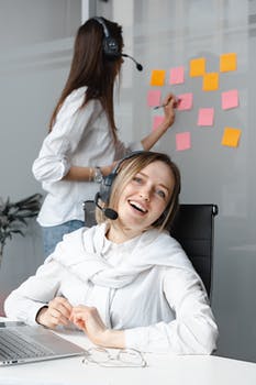 Smiling woman in white long sleeve shirt working as a call center agent