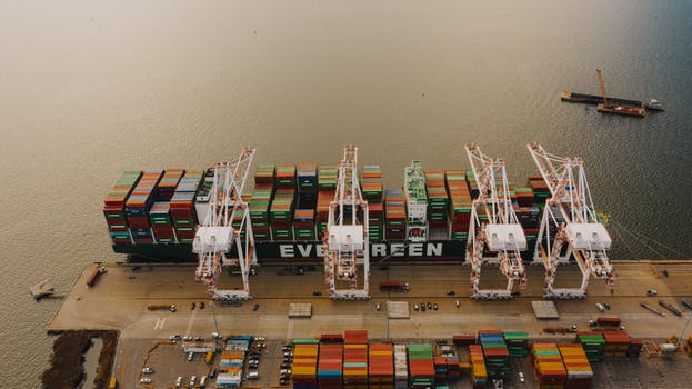 Cargo ship near pier with lifting cranes