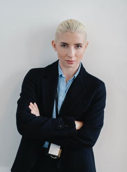 Positive woman in formal clothes standing with arms crossed