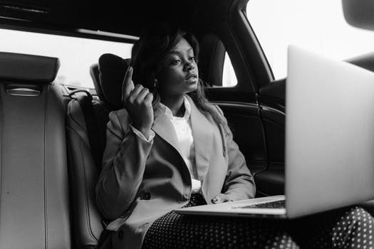 Grayscale photo of woman sitting inside a car