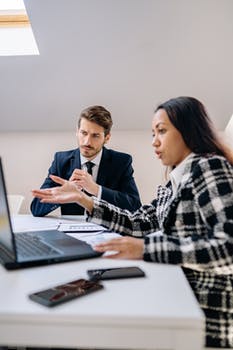 A man and a woman looking at a laptop at an office