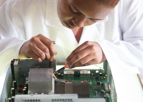 Crop focused repairman fixing graphics card on computer