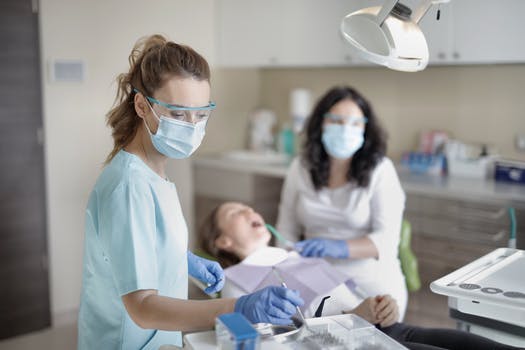 Female dentist treating her patient