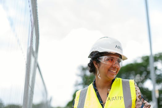 Photo of female engineer wearing hard hat and yellow vest 