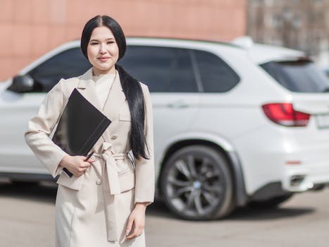 Woman in beige corporate clothes holding black folder