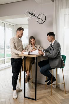 Man in gray jacket showing papers to a couple to sign