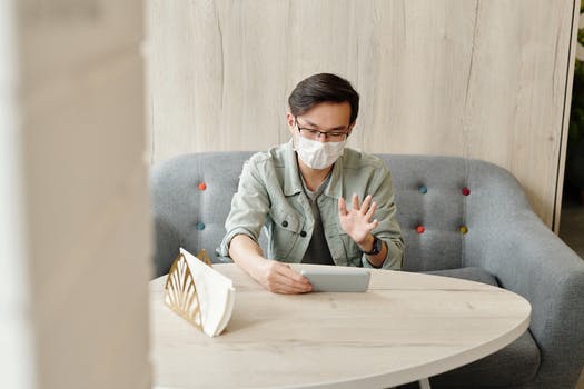 Man wearing a face mask having a video call