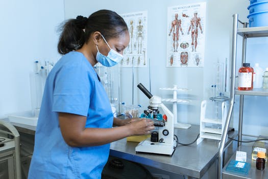 A laboratory scientist using a microscope inside the laboratory