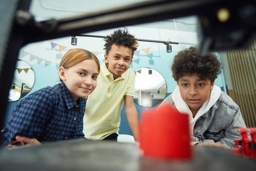 Group of diverse friends observing 3d printer