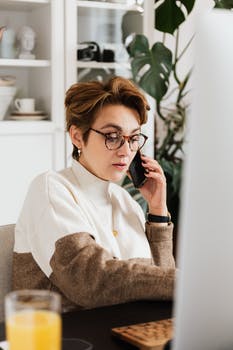 Serious director talking on cellphone in cozy office 