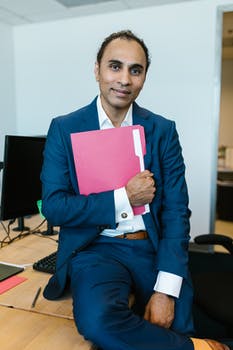 Man in blue suit holding a folder