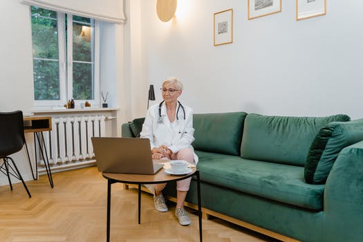 Woman in white blazer sitting on green sofa