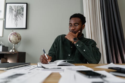 Man in green dress shirt holding pen