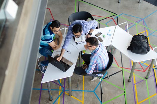 Top view photo of 3 men in front of laptop 