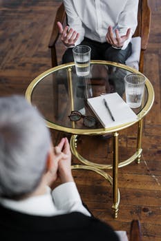 Woman in black long sleeve shirt sitting on brown wooden chair