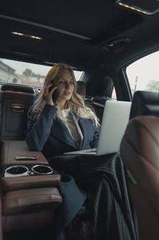 Woman in gray business suit sitting in a luxurious car