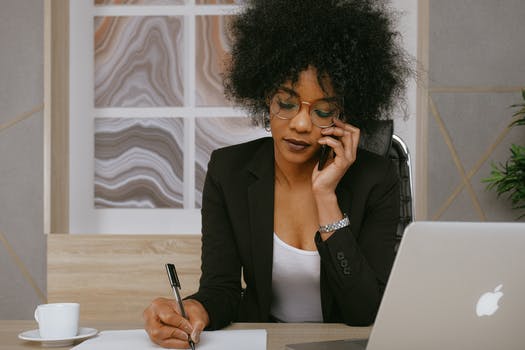 Woman in black blazer holding smartphone