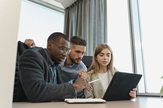 Employees looking at the screen of a tablet