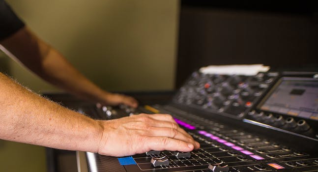 Close up of a person s hands on audio mixer