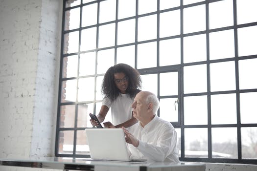 Focused diverse coworkers of different age discussing job project in creative workplace