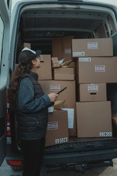 A woman checking a van delivery contents