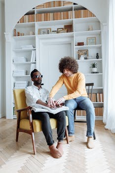 Man in yellow long sleeve shirt sitting beside woman in pink long sleeve shirt